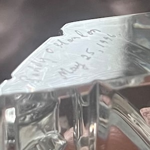 May include: A clear glass paperweight with the inscription "Holly & John May 25, 1996".