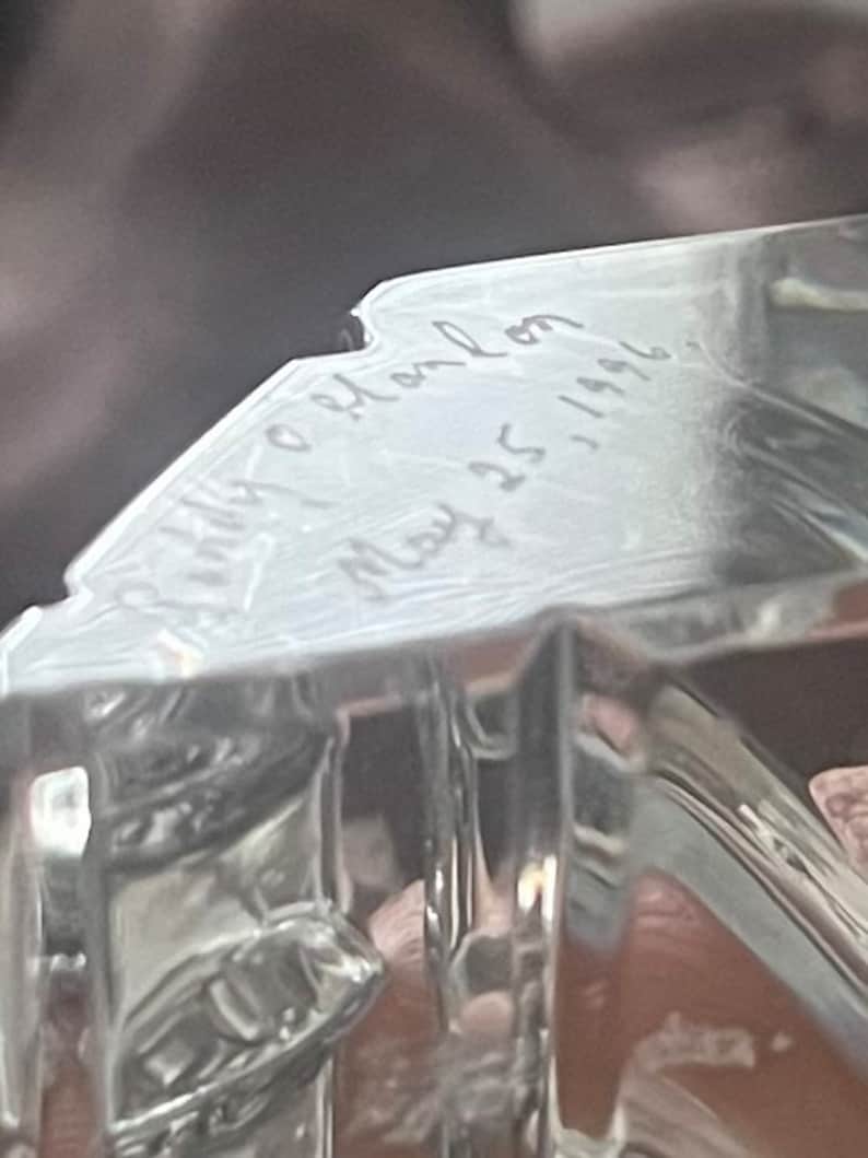 May include: A clear glass paperweight with the inscription "Holly & John May 25, 1996".
