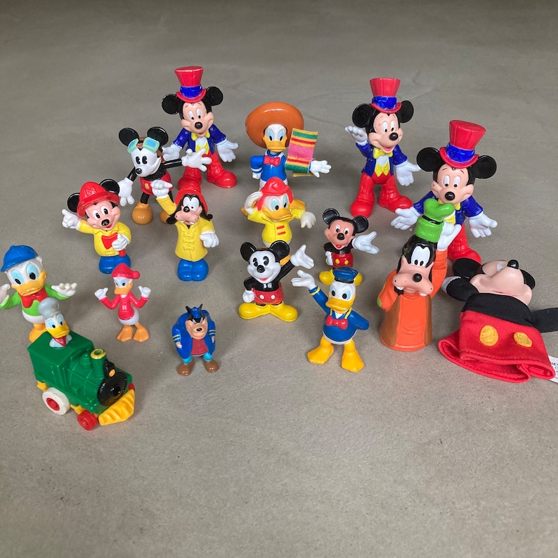 May include: A collection of 16 colorful plastic Disney character figurines, including Mickey Mouse, Minnie Mouse, Donald Duck, Goofy, and Pluto. The figurines are all in different poses and are made of a durable plastic.