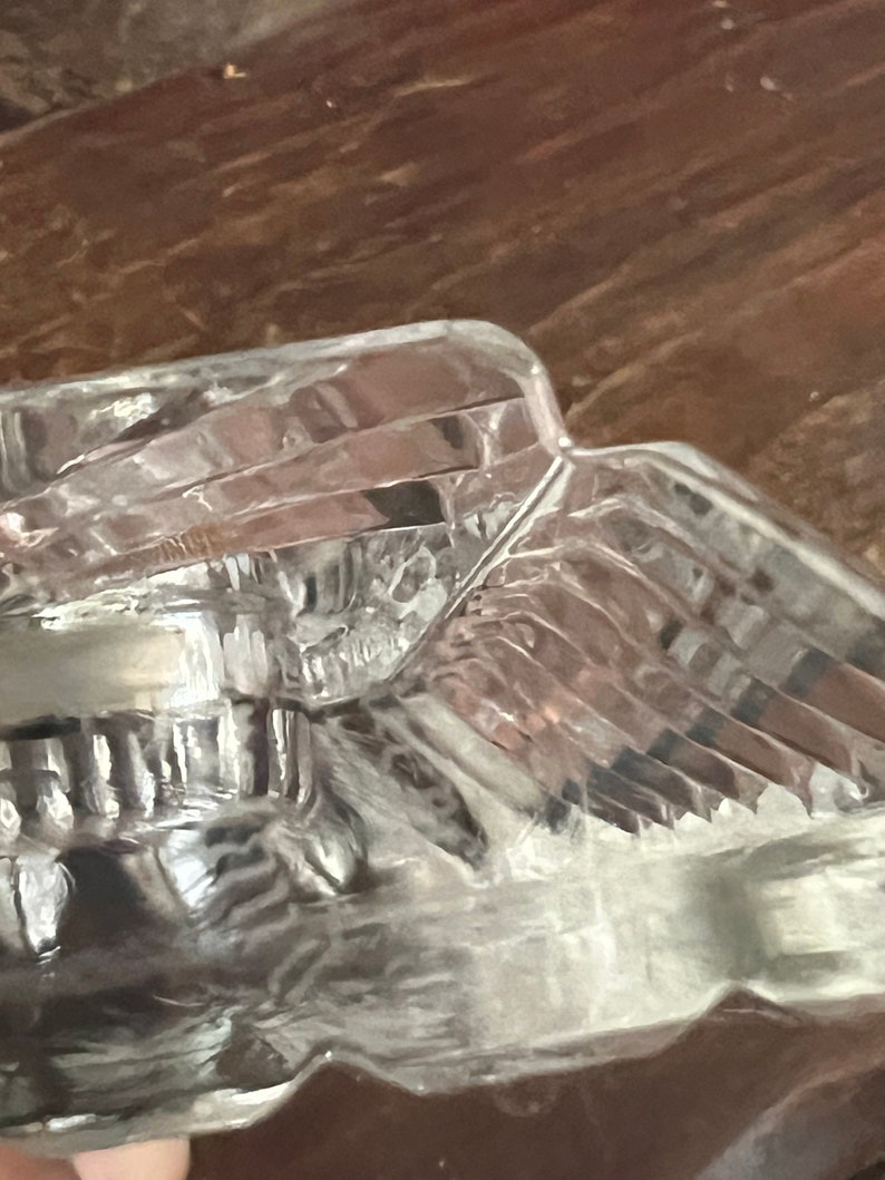 May include: A clear glass bowl with a textured, faceted design. The bowl is made of thick glass and has a rounded shape.