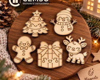 Può includere: Un set di cinque decorazioni natalizie in legno chiaro con disegni incisi di un albero sorridente, un pupazzo di neve, un omino di pan di zenzero, un regalo con fiocco e una renna, disposti su una superficie circolare in legno.