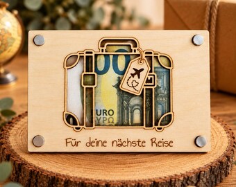 Può includere: Una targa rettangolare in legno chiaro con un intaglio a forma di valigia. L'intaglio della valigia mostra una banconota da 100 euro. È attaccata una piccola etichetta per bagagli in legno con l'icona di un aereo e un cuore.