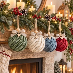 Könnte beinhalten: Vier runde, gehäkelte Weihnachtskugeln hängen in einer Reihe. Jede Kugel hat ein strukturiertes Spiralstrickmuster in Grün, Creme, Blau oder Rot. Eine beigefarbene Schleife, ein kleiner Holzstern und eine Holzperle zieren jede Kugel.