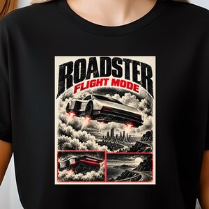 Könnte beinhalten: Ein schwarzes T-Shirt mit einem Grafikdruck und dem Text "ROADSTER FLIGHT MODE". Das Design zeigt ein Auto, das über einer Skyline schwebt, sowie kleinere Felder mit dem Auto auf einer Straße und einer Küstenlandschaft bei Nacht.