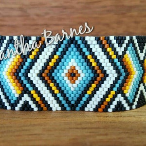 May include: A beaded bracelet with a geometric pattern in black, white, blue, orange, and yellow.