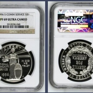 May include: A 1996 S Community Service silver dollar coin graded PF 69 Ultra Cameo by NGC. The obverse features Liberty with the text National Community Service, 1996, and In God We Trust. The reverse displays a wreath with Service For America.