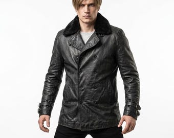 Puede incluir: Una chaqueta cruzada de color gris carbón con cuello de piel sintética negra, mangas largas con correas de doble hebilla en los puños y un acabado texturizado. La prenda se lleva sobre una camisa gris claro y pantalones de color negro.