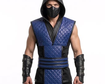 Puede incluir: Un chaleco sin mangas azul y negro acolchado con capucha, combinado con una máscara facial negra y protectores de antebrazo negros a juego con tres correas de hebilla. El chaleco tiene una textura de rombos y un panel frontal largo y superpuesto.