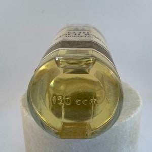 May include: A clear glass bottle with a yellow liquid inside. The bottle has a label with the text "Echt Schwarzw&auml;lder Kirschwasser" and "Doppelfeine" on it. The bottom of the bottle has the text "450 ccm".