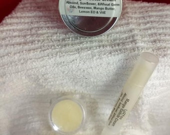 May include: Three containers of Lu2You Mango Cuticle Cream. The cream is packaged in a small metal tin, a small glass jar, and a small clear plastic tube. The label on the tin reads "Lu2You Mango Cuticle Cream Almond, Sunflower, &Wheat Germ Oils, Beeswax, Mango Butter, Lemon EO & VitE".