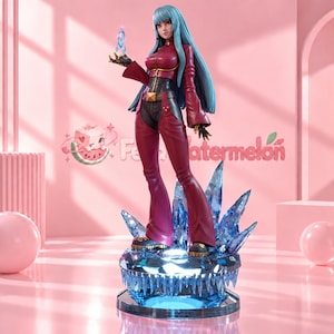 Pode incluir: Uma figura colecionável de uma personagem com longos cabelos azul-claros, vestindo uma jaqueta vermelho-escura e calças largas combinando com detalhes pretos. A figura está sobre uma base de cristal azul e segura um cristal azul brilhante.