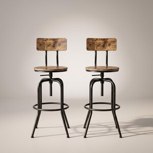 Puede incluir: Dos taburetes de bar ajustables con asientos redondos de madera y respaldos rectangulares de madera con acabado de veta marrón. Los taburetes cuentan con estructuras de metal negro de cuatro patas, un reposapiés circular y un mecanismo central.