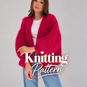May include: A bright fuchsia, chunky knit cardigan with long, voluminous sleeves and a ribbed texture, worn over a plain white t-shirt and light blue denim jeans. The image features the white text overlay Knitting Pattern.