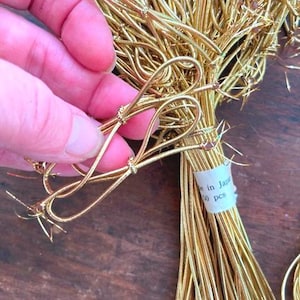 May include: A bundle of 50 gold elastic cords with a knotted end. The cords are made in Japan.