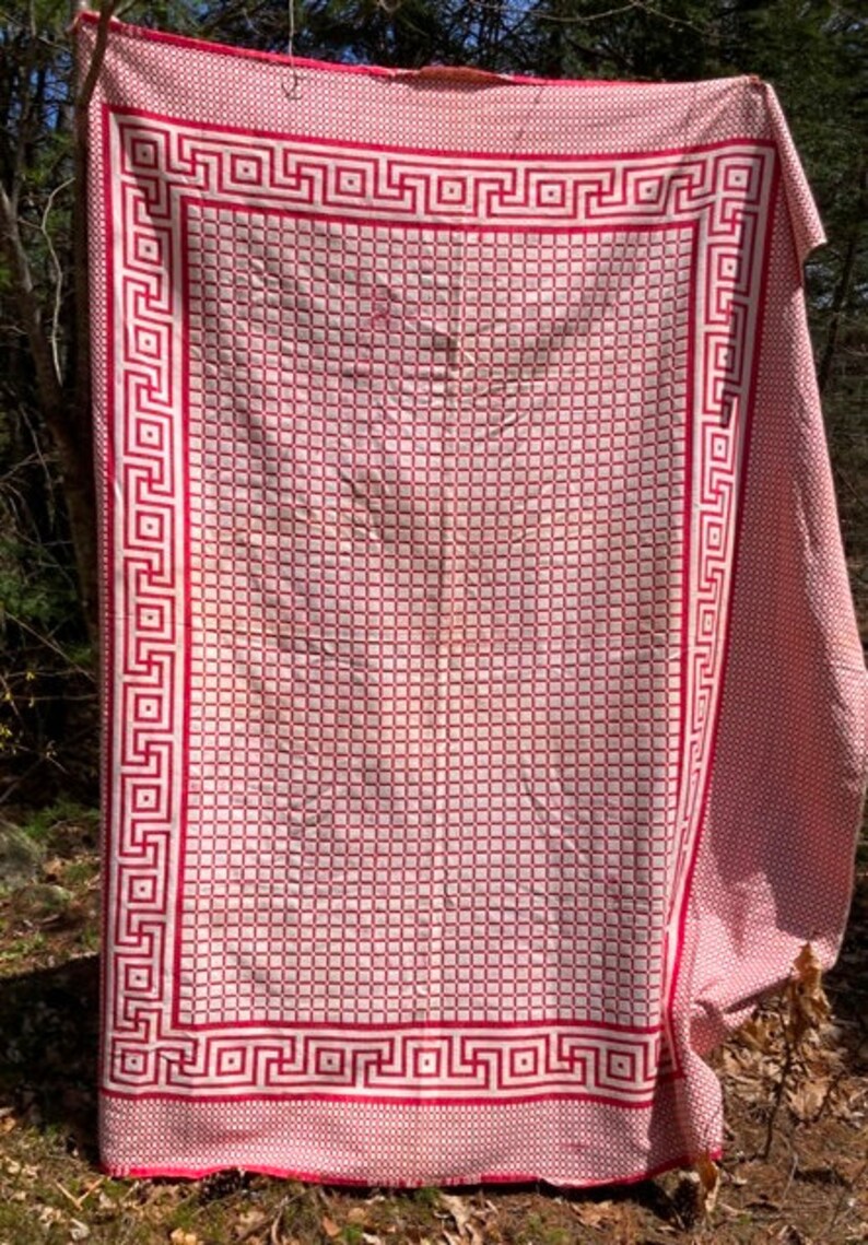 May include: A red and white checkered tablecloth with a Greek key border. The tablecloth is made of a woven fabric and has a vintage look.
