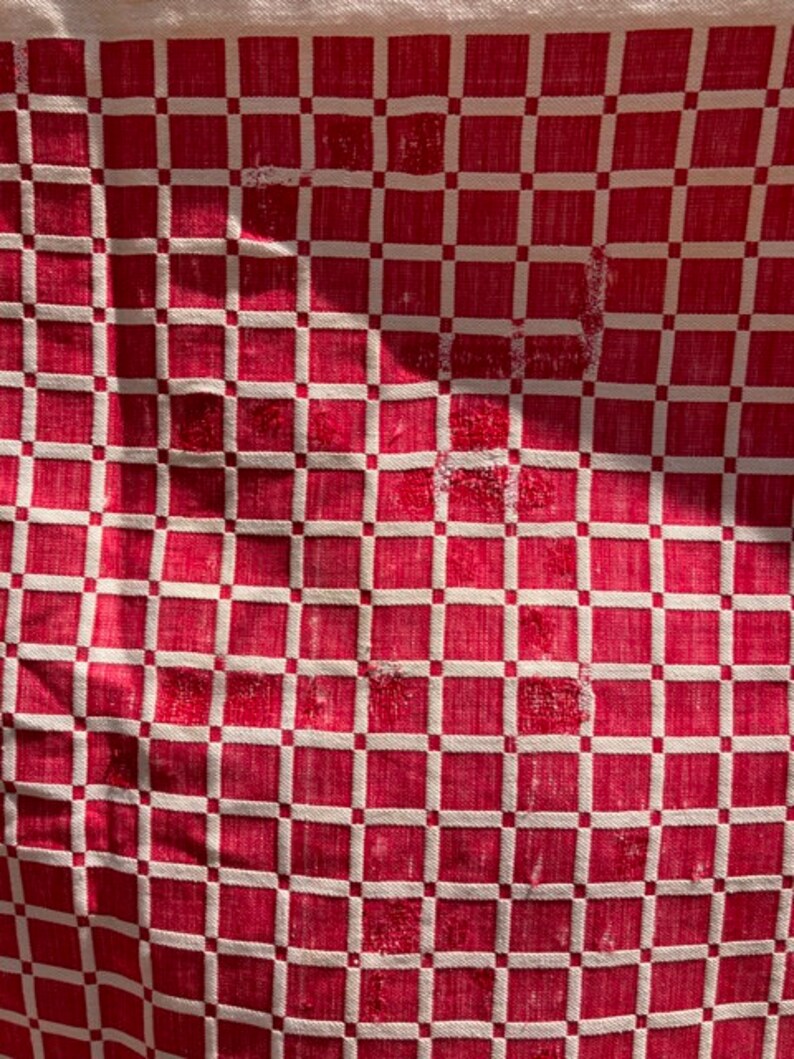 May include: Red and white checkered fabric with a woven pattern. The fabric has a slightly distressed look, with some of the threads pulled loose.