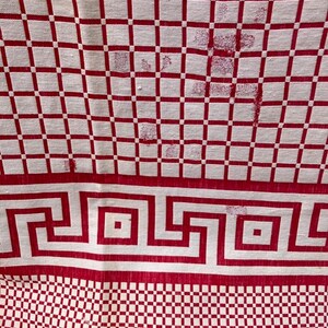 May include: Red and white checkered tablecloth with a red Greek key border. The tablecloth has a worn look with some small holes.