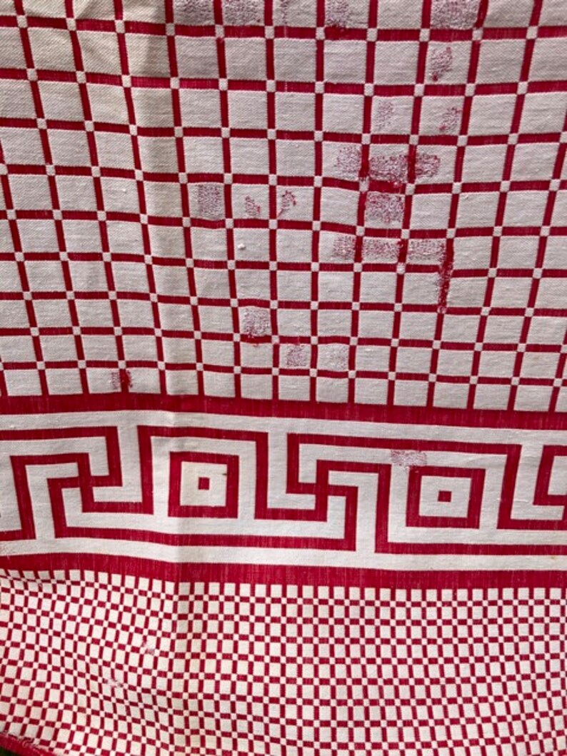 May include: Red and white checkered tablecloth with a red Greek key border. The tablecloth has a worn look with some small holes.