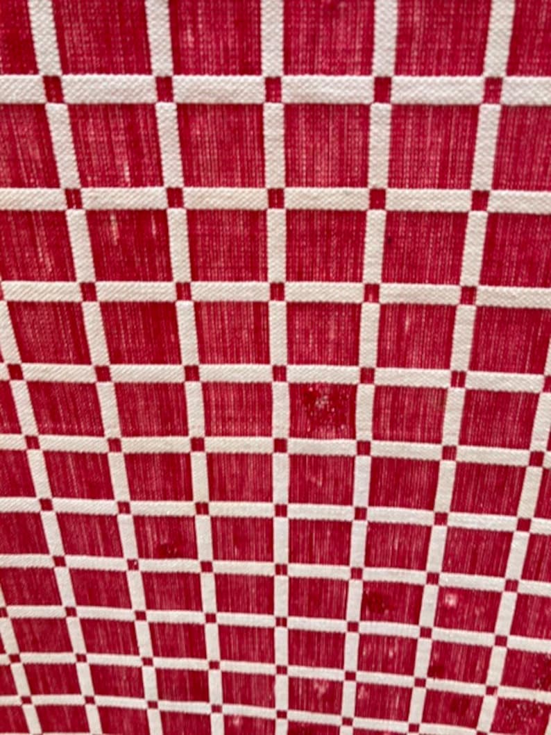 May include: Red and white checkered fabric with a woven texture.