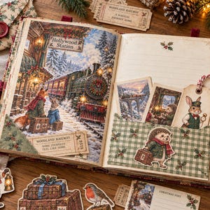 Peut inclure: Un album ouvert présentant une illustration de gare ferroviaire hivernale avec un renard et un lapin, une pochette à carreaux verts contenant trois cartes illustrées et un billet marqué Woodland Railway. Les pages incluent des images festives.
