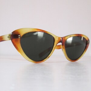 Puede incluir: Gafas de sol vintage de ojo de gato con estampado de carey. Las monturas son una mezcla de &aacute;mbar y marr&oacute;n, con lentes oscuras. Dise&ntilde;o retro cl&aacute;sico.