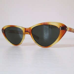 Puede incluir: Gafas de sol vintage de ojo de gato con un patr&oacute;n de carey. Las monturas son &aacute;mbar y marr&oacute;n, con lentes oscuras. Las gafas de sol tienen un dise&ntilde;o cl&aacute;sico y retro.