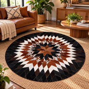 Puede incluir: Una alfombra circular con un patrón geométrico de estrella compuesto por parches de cuero cosidos en tonos negro, blanco, marrón y piel de vaca moteada. El diseño irradia desde el centro en un motivo repetitivo de diamantes y triángulos.