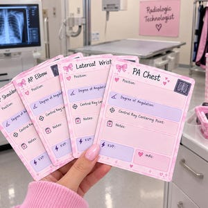 May include: A set of four rectangular reference cards with a pink and white checkered background, featuring headers for AP Shoulder, AP Elbow, Lateral Wrist, and PA Chest. Each card includes fields for position, degree of angulation, central ray, notes, KVP, and mAS.