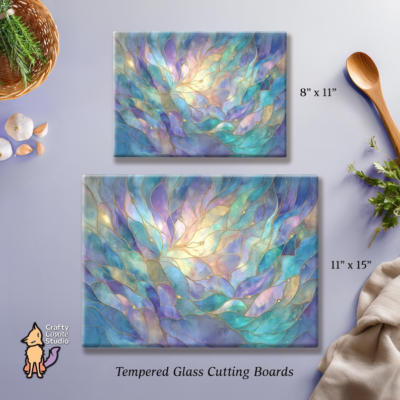May include: Two tempered glass cutting boards with an abstract design in shades of blue, purple, and gold. The larger board measures 11 x 15 inches, and the smaller one is 8 x 11 inches. The text "Tempered Glass Cutting Boards" is at the bottom.