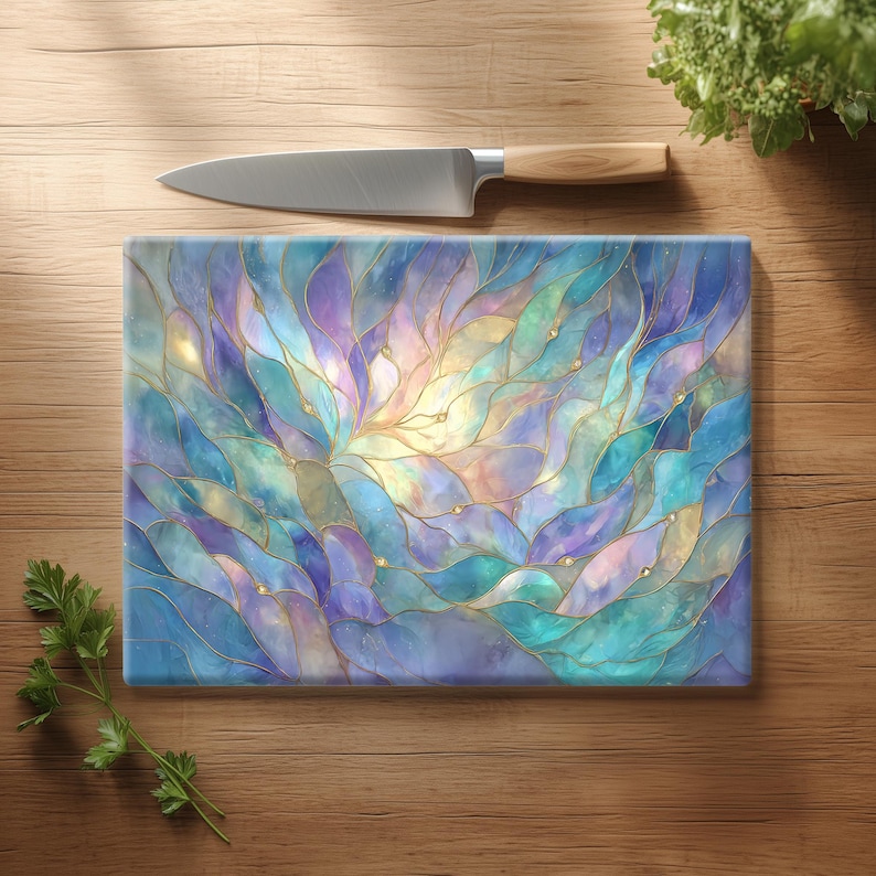 May include: Rectangular glass cutting board with a colorful abstract design in shades of blue, purple, and gold. A stainless steel knife with a wooden handle rests on a wooden surface, along with fresh herbs.