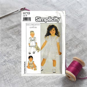 May include: Simplicity sewing pattern 8713, size 3, featuring a Jessica McClintock for Gunne Sax design. The white paper envelope displays illustrations and a photograph of a child wearing a short-sleeved white dress with lace trim.