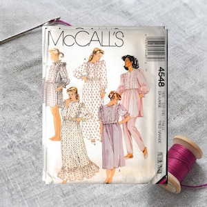 May include: A McCall's 4548 sewing pattern envelope for size extra-large. The front features illustrations of four different garment styles, including dresses and a tunic with pants, all with long sleeves and button-front details.