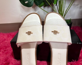 White slide mules with gold tone logo