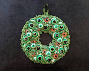 Corona de Halloween con forma de globo ocular pintada a mano: decoración verde y naranja difusa