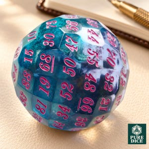 May include: A multi-faceted, spherical 100-sided die featuring a translucent teal and blue marbled resin finish. The numbers are engraved in a bright pink font, clearly displaying values ranging from 10 to 99 across its many geometric faces.