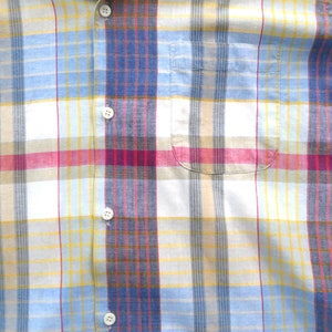May include: A white, blue, yellow, and red plaid button-up shirt with a pocket on the left side.