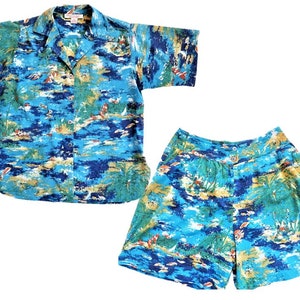 May include: A blue and green tropical print short-sleeved shirt and matching shorts set. The fabric features a beach scene with palm trees, boats, and a blue sky.