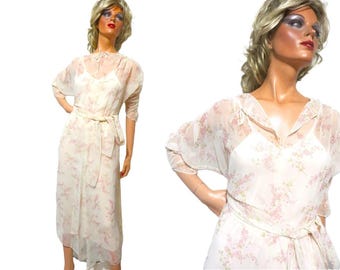 May include: A white sheer dress with a floral pattern and a matching sash. The dress has a V-neckline and 3/4 sleeves.