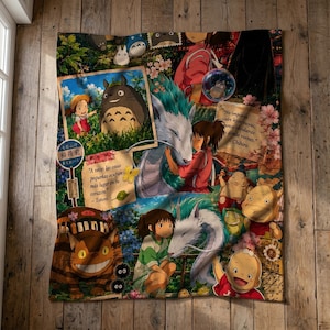 Könnte beinhalten: Eine rechteckige Wohndecke mit einer Collage aus Studio Ghibli-Figuren wie Totoro, Chihiro, Haku und dem Katzenbus. Das Design enthält florale Elemente, japanischen Text und spanische Zitate wie A veces las cosas pequeñas ocupan más lugar en tu corazón.