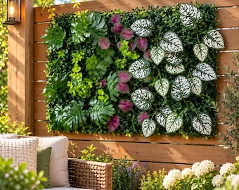 May include: A rectangular artificial plant wall panel featuring a dense mix of green foliage, including large monstera leaves, small bright green sprigs, purple-tinted leaves, and heart-shaped leaves with a white speckled pattern.