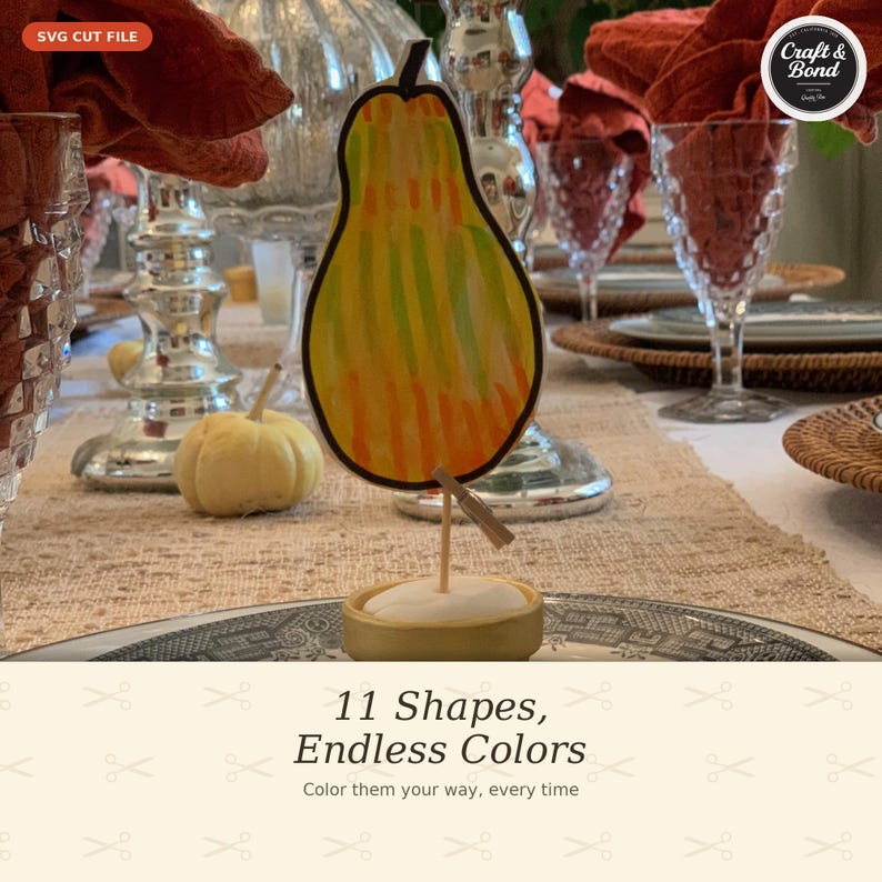 May include: A pear-shaped cutout with vertical stripes in shades of yellow, orange, and green. The cutout is attached to a small wooden base by a thin stick and a miniature clothespin. Text on the image reads SVG CUT FILE and 11 Shapes, Endless Colors.