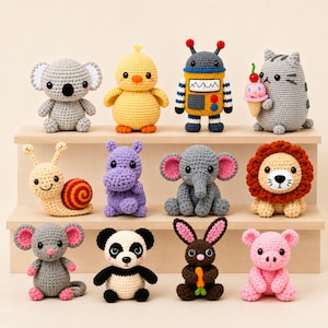 Può includere: Una collezione di dodici piccoli animali e figure all'uncinetto, tra cui un koala, un pulcino, un robot, un gatto con gelato, una lumaca, un ippopotamo, un elefante, un leone, un topo, un panda, un coniglio con carota e un maialino.