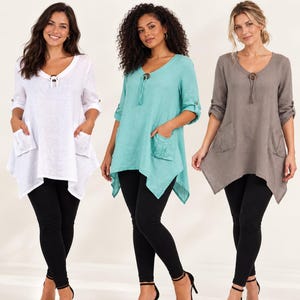 May include: Three linen handkerchief hem tops in white, teal, and taupe. Each top features a V-neckline with a decorative button, roll-tab sleeves, and two front patch pockets. The text reads: Linen Handkerchief Hem Top, Patch Pockets, Roll-Tab Sleeves.