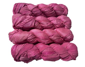 May include: Four bundles of pink sari silk ribbon, tightly twisted and arranged in a layered composition. The silk has a textured appearance, with variations in the pink hue. The ribbons are likely used for crafting or embellishment.