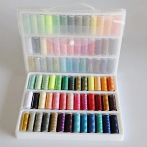 May include: A clear plastic storage box with a handle, containing a variety of colorful spools of thread. The spools are organized in rows and columns, with each row containing a different color.