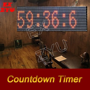May include: A rectangular LED digital display board featuring a grid of small lights that show the red glowing numbers 59:36:6. The electronic device is mounted horizontally against a wall, displaying time or countdown digits in a clear, bright format.