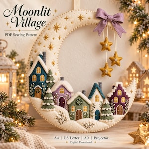 May include: A crescent moon-shaped felt wall hanging featuring a village of small houses and pine trees. The cream-colored moon is decorated with embroidered gold stars, a lavender bow, and three hanging gold stars. Text reads Moonlit Village PDF Sewing Pattern, A4, US Letter, A0, Projector, Digital Download.