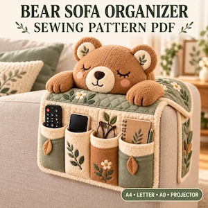 May include: A bear sofa organizer sewing pattern PDF featuring a plush brown bear head with closed eyes and four pockets. The organizer is quilted in sage green and cream with floral embroidery, holding a remote, phone, glasses, and notebook.