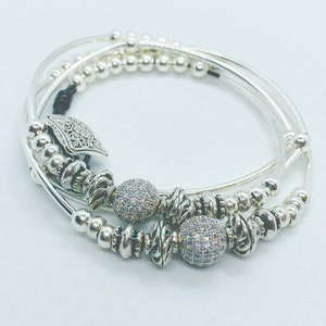 0182 Three layer leather bracelet made with silver plated beads, crystals, tubes and pave ball beads. Button clasp.