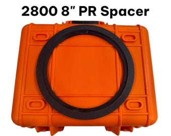 May include: A black circular spacer resting on a bright orange rectangular hard-shell case. The text 2800 8" PR Spacer is printed in black above the case. The spacer has a flat, textured surface and a uniform ring shape.